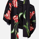Introducing the Rita Off The Shoulder Draped Top with Scarf by ALICE + OLIVIA—a cropped, off-the-shoulder black top crafted from luxurious floral silk charmeuse, adorned with vibrant red and white tulip prints and green leaves, elegantly showcased against a plain white background.