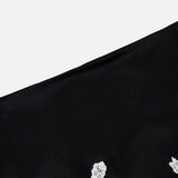 A close-up of the Rubi Lace Trim Low Rise Micro Skirt by ALICE + OLIVIA, featuring black fabric and white floral cutwork lace trim at the hem, set against a plain light background.