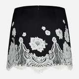 The Rubi Lace Trim Low Rise Micro Skirt by ALICE + OLIVIA features white floral cutwork lace trim, a scalloped hem, and a low rise fit, shown against a plain white background.