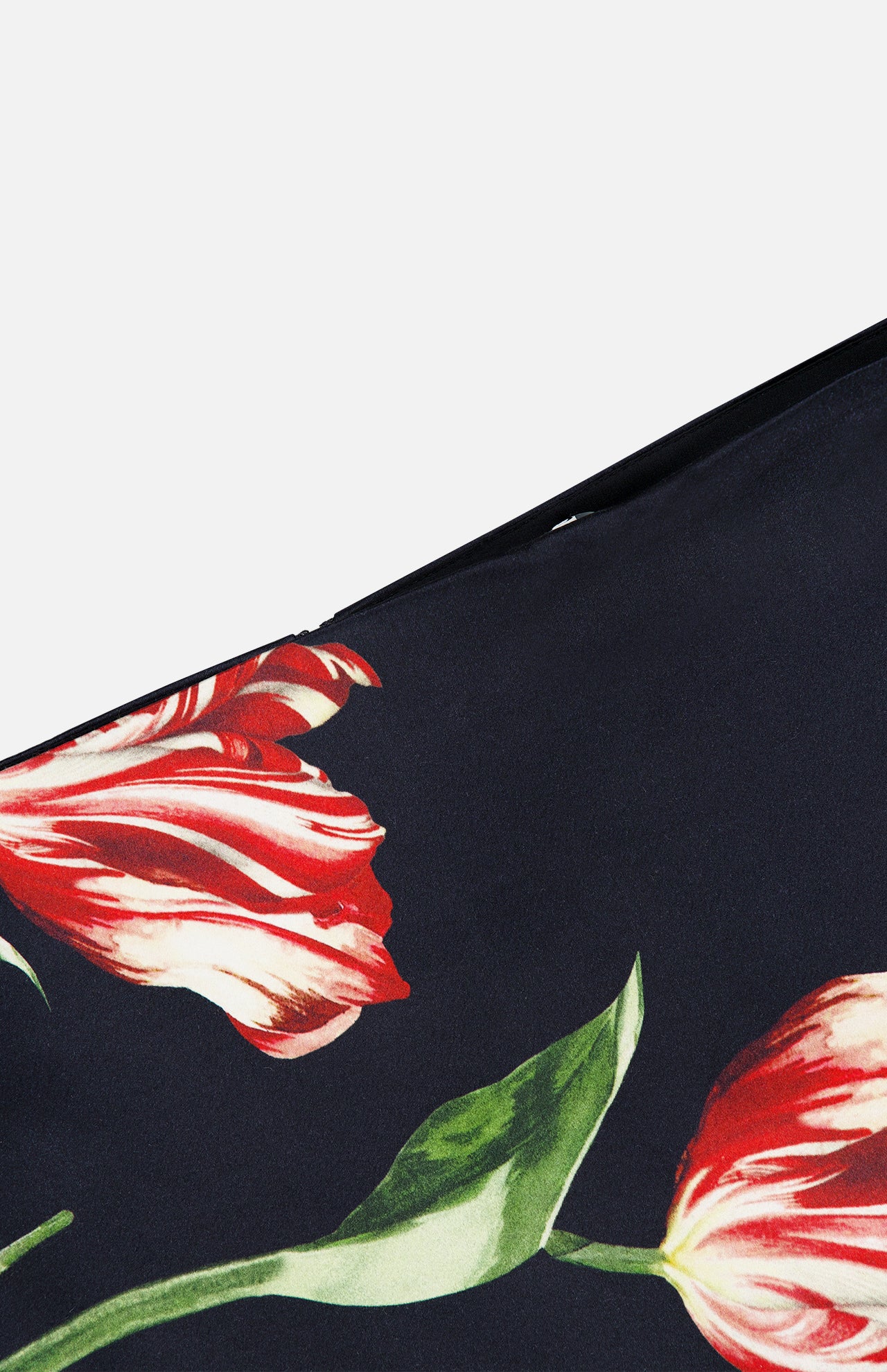 Close-up of the Rubi Low Rise Floral Skirt by ALICE + OLIVIA, showcasing a romantic print with red and white tulips and green stems and leaves against a black background.