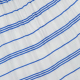The Saige Halter Tiered Maxi Dress by ALICE + OLIVIA features white fabric adorned with evenly spaced horizontal blue stripes of varying thickness. Gathered elastic at the top and a flowing tiered silhouette create a fresh, seaside-inspired look, making this white maxi dress the perfect choice for breezy summer days.
