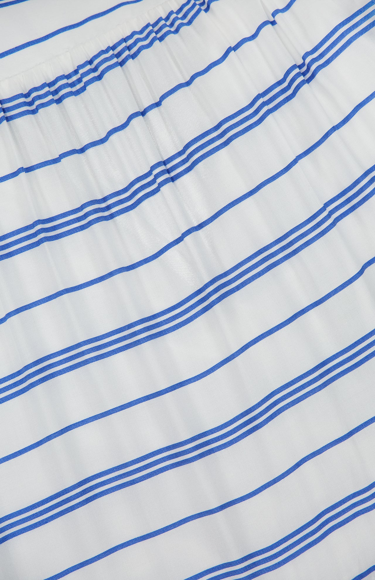 The Saige Halter Tiered Maxi Dress by ALICE + OLIVIA features white fabric adorned with evenly spaced horizontal blue stripes of varying thickness. Gathered elastic at the top and a flowing tiered silhouette create a fresh, seaside-inspired look, making this white maxi dress the perfect choice for breezy summer days.