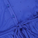 Close-up of the Thalia Puff Sleeve Tunic Dress by ALICE + OLIVIA in cobalt blue, showcasing small embroidered holes in eyelet cotton voile, fabric-covered buttons, a braided waist tie, and a floral lace pattern on the skirt for a bohemian-inspired look.