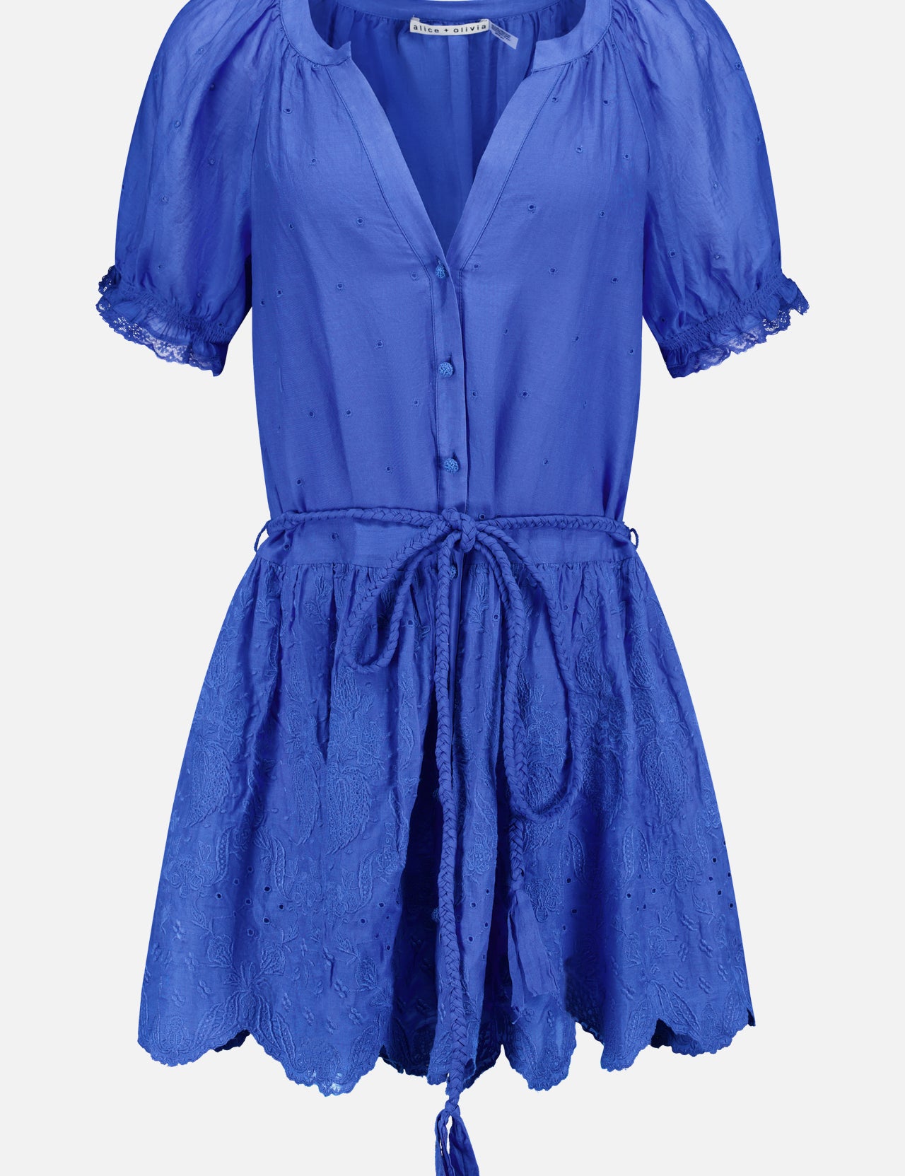 The Thalia Puff Sleeve Tunic Dress by ALICE + OLIVIA is a bright cobalt blue, short-sleeved dress featuring buttons down the front, a tied waist belt with tassels, and an embroidered flared skirt. Crafted from lightweight, slightly textured eyelet cotton voile, this tunic blends effortless style with breezy bohemian flair.