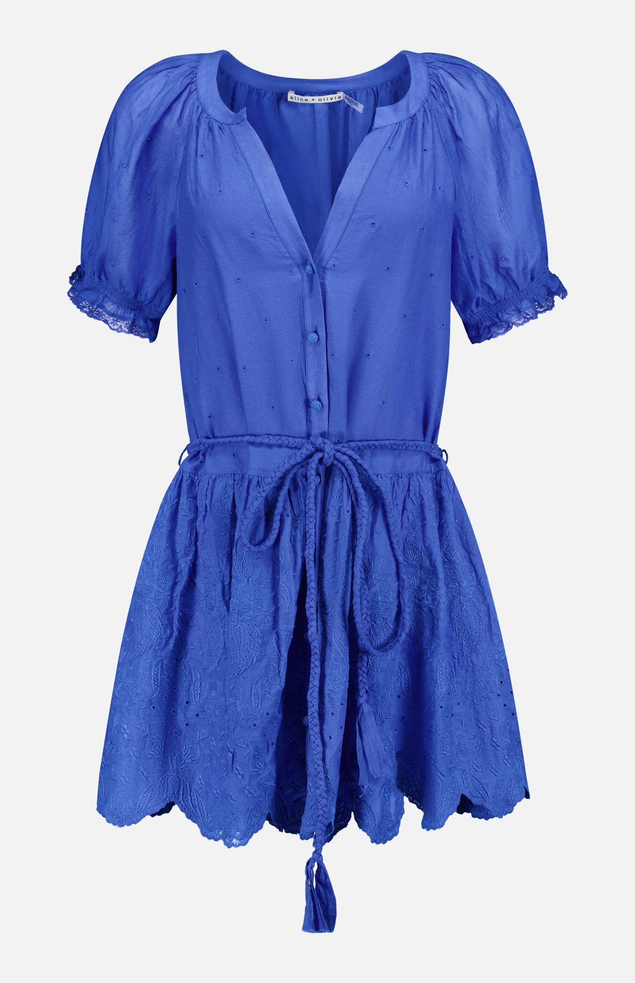 The Thalia Puff Sleeve Tunic Dress by ALICE + OLIVIA is a bright cobalt blue, short-sleeved dress featuring buttons down the front, a tied waist belt with tassels, and an embroidered flared skirt. Crafted from lightweight, slightly textured eyelet cotton voile, this tunic blends effortless style with breezy bohemian flair.