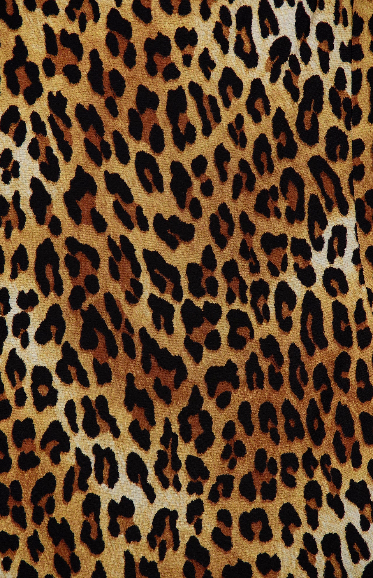 Close-up of a leopard print fabric, featuring black irregular spots on a golden-yellow and tan background—ideal for crafting the Wendy Fit And Flare Godet Mini Dress by ALICE + OLIVIA.