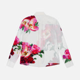 The ALICE + OLIVIA Willa Hidden Placket Silk Top is a white long-sleeve button-up shirt with bold pink and red floral prints and green leaves on the back and sleeves, set against a plain white background.