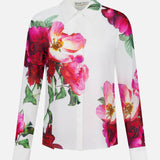 The Willa Hidden Placket Silk Top by ALICE + OLIVIA is a white collared blouse with bold pink and red floral prints and green leaves adorning the front and sleeves.