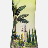 The Wynell Staceface Fitted Mini Dress by ALICE + OLIVIA is a sleeveless yellow mini dress showcasing a scenic print with tropical plants, flowers, trees, a stone clock tower, and sea views—perfect for effortless summer style.