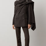 A person wears a dark brown RALPH LAUREN COLLECTION Mini Herringbone Blazer with matching trousers and a detachable scarf draped over their shoulders, secured with a decorative brooch.