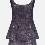 The Empire Sparkle Tweed Mini Dress by AMANDA UPRICHARD features a sleeveless design in black and silver tweed, a fitted bodice, scoop neckline, peplum waist, and two front flap pockets with decorative buttons.