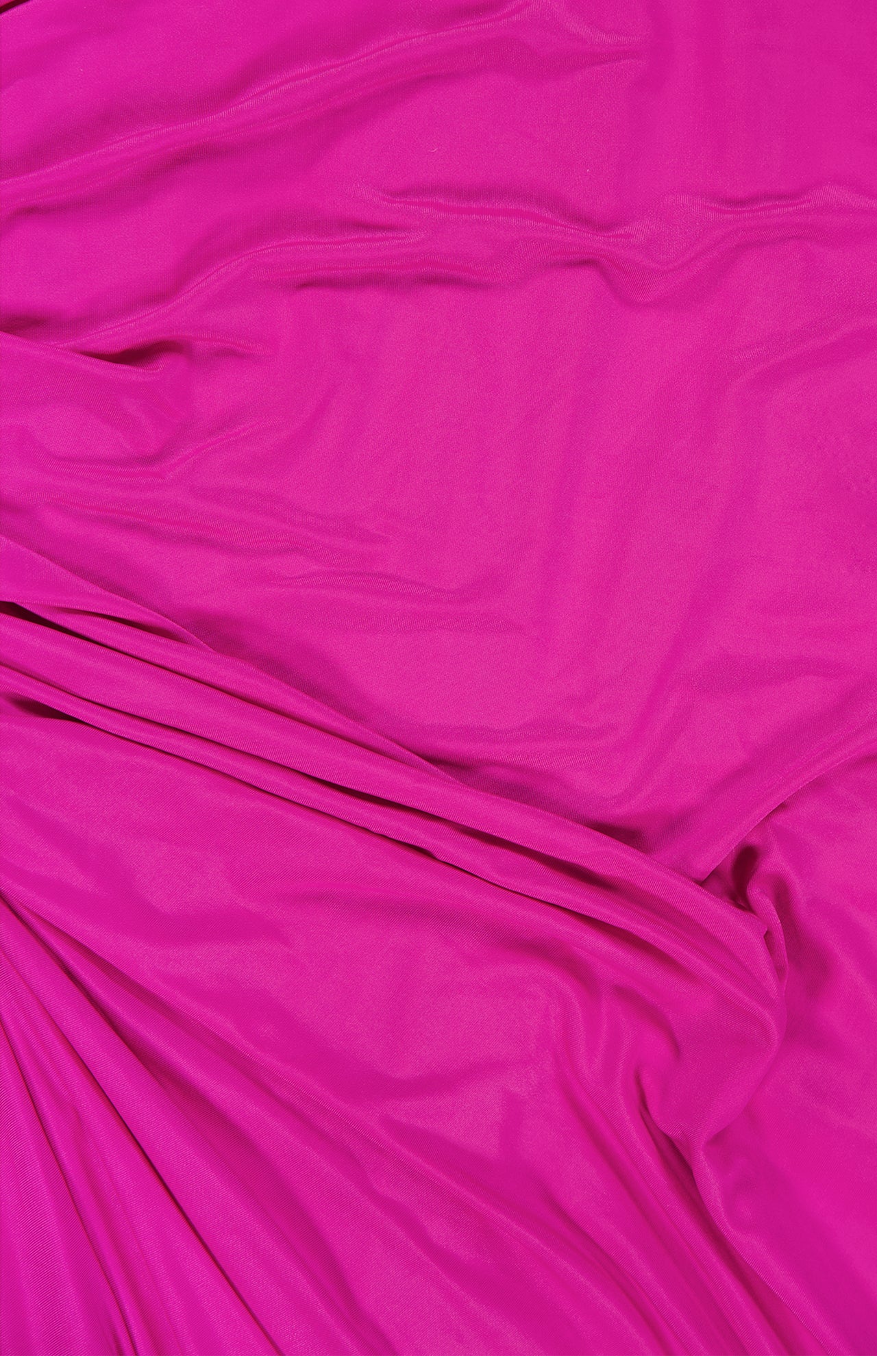 The Brooke Ruched One Shoulder Dress by AMANDA UPRICHARD features bright pink fabric with gentle drapes, creating soft, flowing lines and subtle shadows reminiscent of a chic hot pink dress.