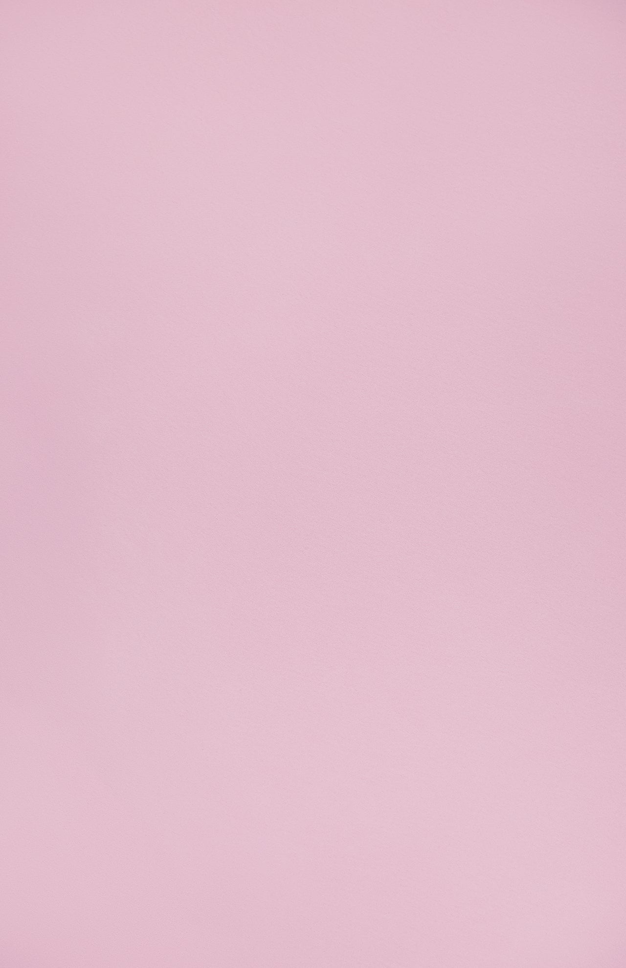 A smooth, light pink background with a soft, even tone—evoking the delicate shade of the Calypso Swingy Mini Dress by AMANDA UPRICHARD.