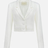 The Courtney Cropped Jacket by AMANDA UPRICHARD is a white tailored blazer with long sleeves, notched lapels, three front buttons, and two small pockets, shown against a plain white background.