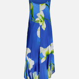 The Gabriella Floral Midi Dress by AMANDA UPRICHARD features thin straps, an asymmetrical hem, and a white and green floral print on blue. Shown against a white background.