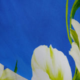 A close-up of the Gabriella Floral Midi Dress by AMANDA UPRICHARD shows its blue fabric with white flowers and green accents—ideal for a stylish, elegant look.