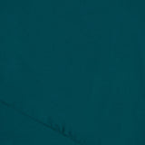 A close-up view of teal fabric from the AMANDA UPRICHARD Jeannine Maxi Dress highlights the diagonal seam, texture, and detailed stitching.