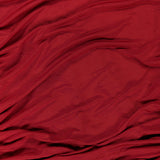 The Katya Draped Panel Mini Dress by AMANDA UPRICHARD features a rich red fabric with soft, wavy folds and ripples that create a textured look reminiscent of gathered ruching. The smooth, slightly glossy material catches the light in certain areas, adding to its elegant and refined appearance.