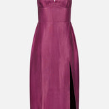 The Lyra Midi Dress by AMANDA UPRICHARD is a sleeveless, knee-length magenta cocktail dress featuring thin straps, a fitted bodice, a structured V-wire notch neckline, and a high side slit on the right side.