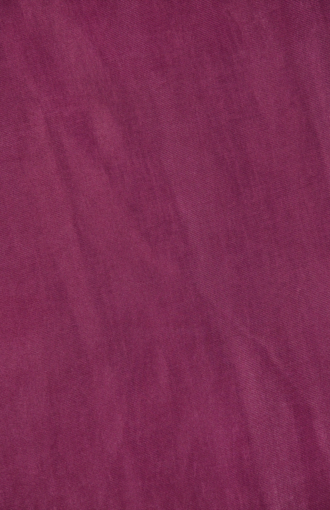 A close-up of deep maroon fabric from the Lyra Midi Dress by AMANDA UPRICHARD, featuring a slightly wrinkled texture and subtle, uneven shading throughout.