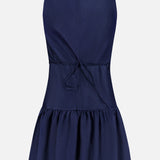 The Margo Drop Waist Skirt Dress by AMANDA UPRICHARD is a sleeveless navy mini with a fitted bodice, tie-back cinched waist, and flared ruffled skirt. Shown from the back on a plain white background in linen organza.