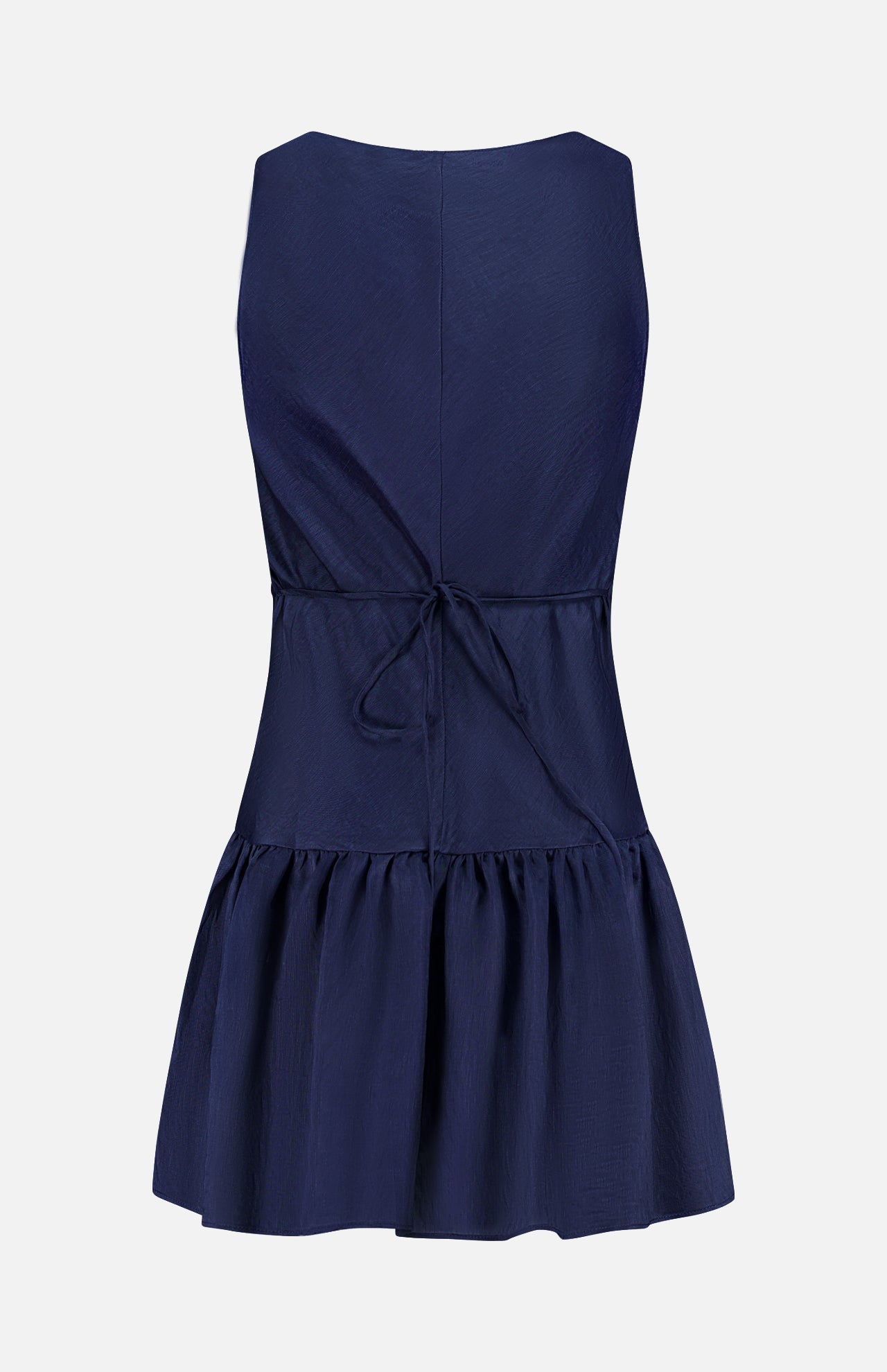 The Margo Drop Waist Skirt Dress by AMANDA UPRICHARD is a sleeveless navy mini with a fitted bodice, tie-back cinched waist, and flared ruffled skirt. Shown from the back on a plain white background in linen organza.