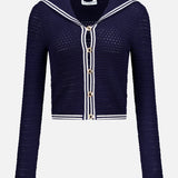 The Monique Sailor Neckline Cardigan by AMANDA UPRICHARD features a navy crochet-knit, long sleeves, white stripe trim, gold front buttons, and a sailor-inspired neckline, shown against a plain white background.