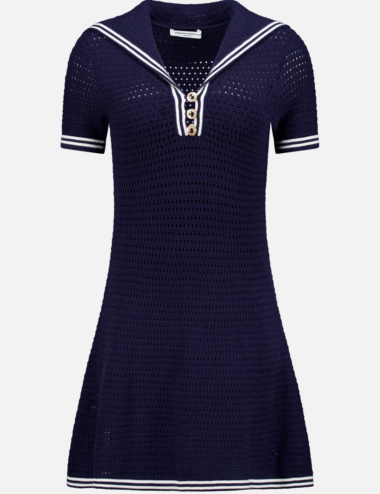 The Monique Sailor Neckline Dress by AMANDA UPRICHARD is a navy blue fit and flare mini dress with short sleeves, white stripe accents, gold front buttons, textured knit fabric, and an airy crochet pattern.