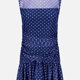 The Rumi Sleeveless Polka Dot Dress by AMANDA UPRICHARD features a navy blue print, high sheer neckline, ruched sides, and flared ruffled skirt—an effortlessly chic mini dress for any occasion.