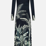 The Donde Empieza Embellished Maxi Dress by ANDRÉS OTÁLORA is a long-sleeved, midnight navy maxi dress featuring a botanical palm print with bold green and white leaves concentrated on the lower half.