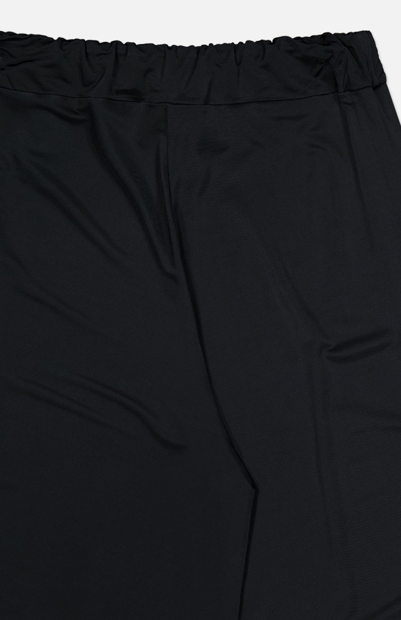 Close-up of En Calma Palm Print Pants by ANDRÉS OTÁLORA, featuring an elastic waistband and smooth fabric, shown against a white background.