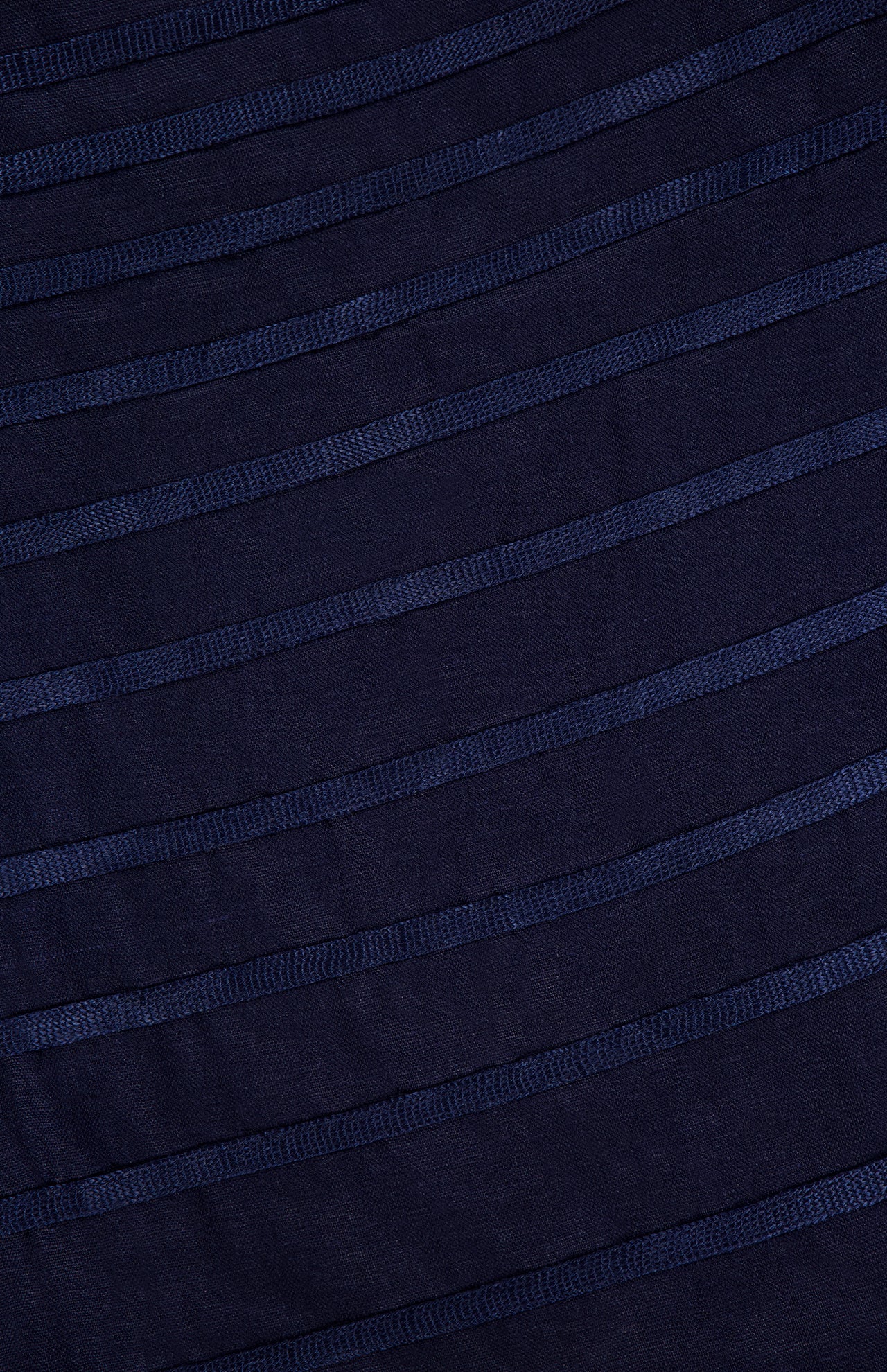 Close-up of the ANDRÉS OTÁLORA Eterna Brisa Embroidered Midi Dress fabric, featuring horizontal textured stripes that create a subtle pattern—an elegant detail for this linen midi dress with adjustable straps.