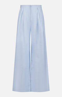 The Naces Tu Linen Pant by ANDRÉS OTÁLORA features a wide-leg, high-waisted baby blue design with front pleats, concealed waistband, and zipper, shown against a plain white background.