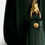 Close-up of the dark green jacquard nylon Anya Hindmarch Logo Girlie Stuff Pouch, featuring a gold-toned zipper and a matching tassel pull with a small hexagonal stud.