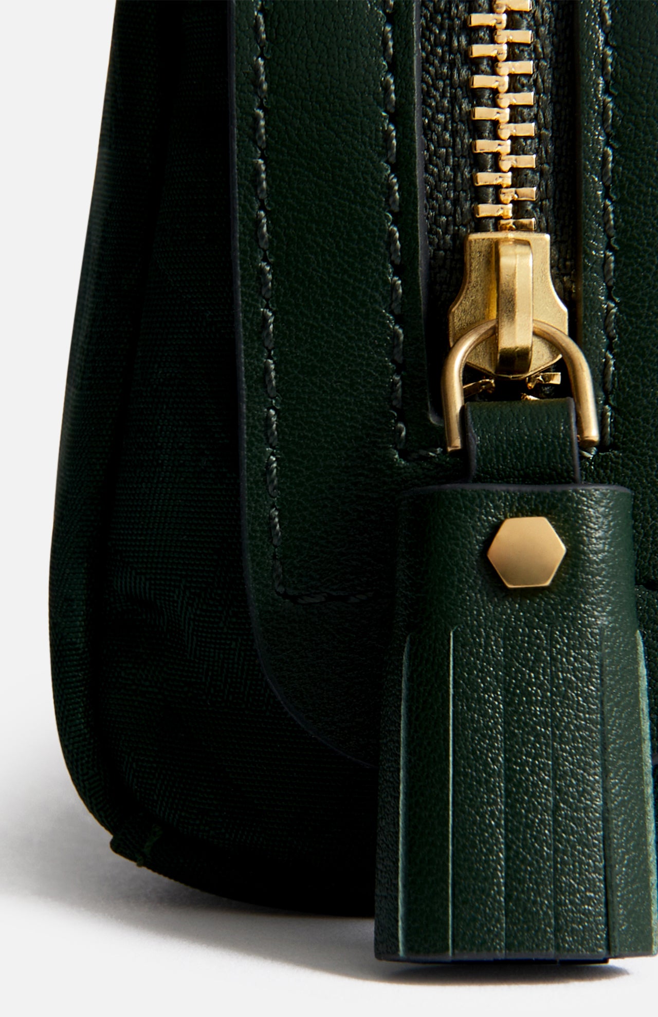 Close-up of the dark green jacquard nylon Anya Hindmarch Logo Girlie Stuff Pouch, featuring a gold-toned zipper and a matching tassel pull with a small hexagonal stud.