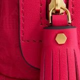 Close-up of a hot pink jacquard nylon Logo Girlie Stuff Pouch by Anya Hindmarch with a matching leather tassel pull and gold hardware.