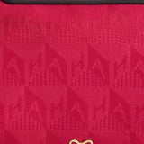 Anya Hindmarch Logo Girlie Stuff Pouch in hot pink jacquard nylon with black leather trim embossed with the words GIRLIE STUFF, featuring a gold bow-shaped logo at the bottom.