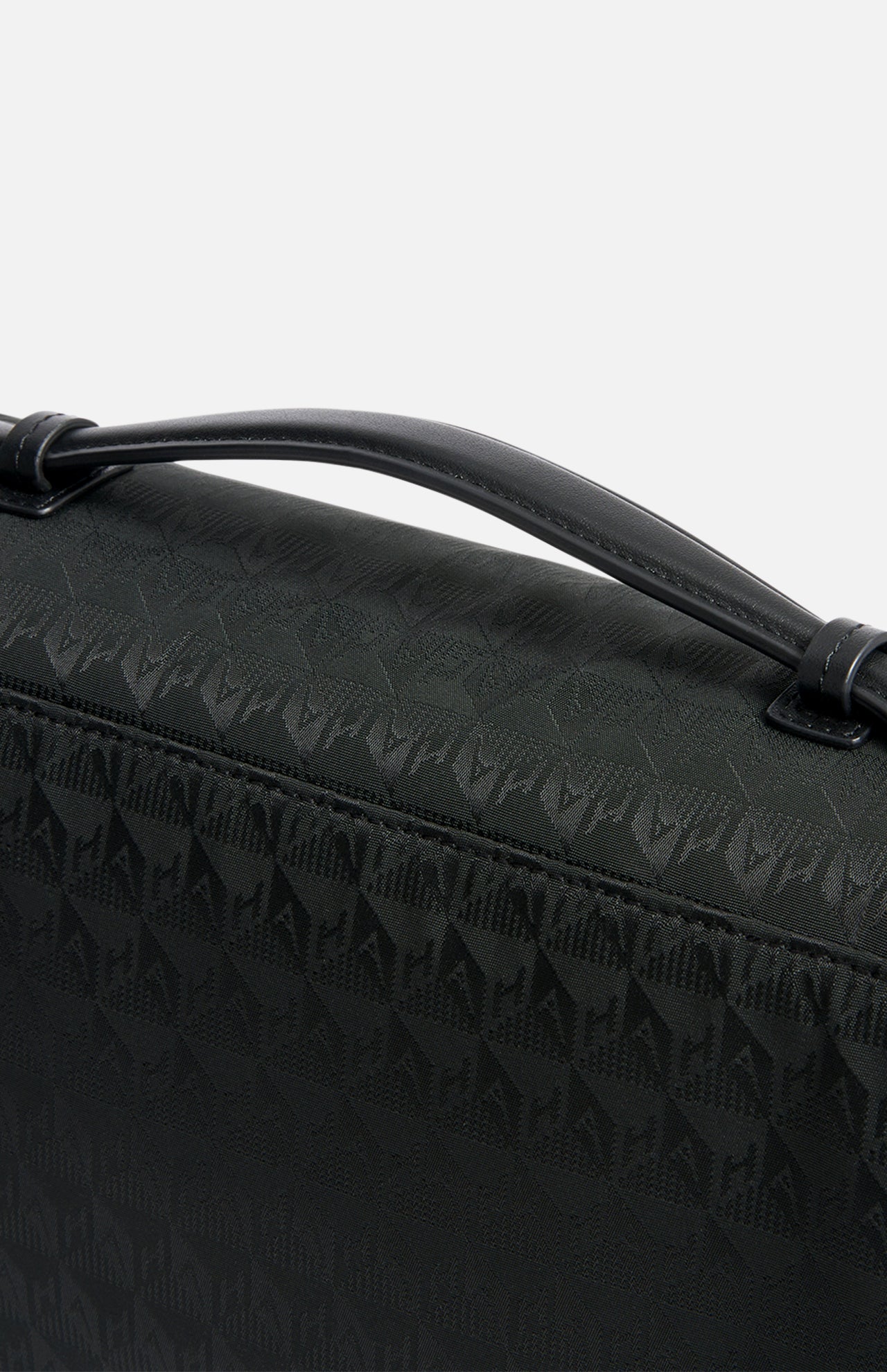 Anya Hindmarch Logo Hair Kit Travel Pouch in black, featuring a repeating geometric logo pattern, a top carry handle, and a spacious interior ideal as a hair tools organizer.