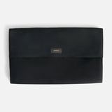 Black rectangular Anya Hindmarch Logo Hair Kit Travel Pouch with a flap closure, featuring a small patch embossed with the word TOOLS in gold lettering.