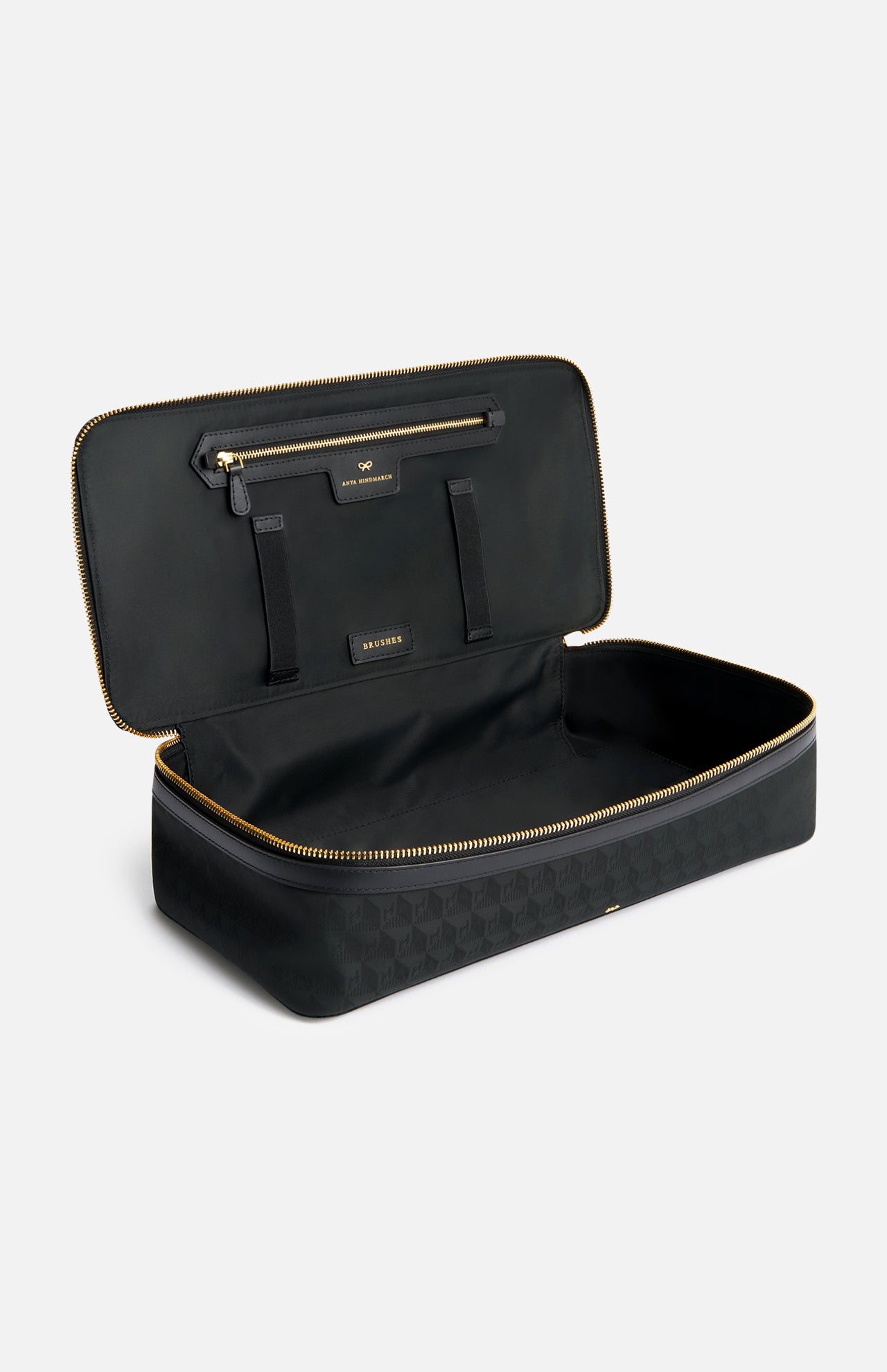 Open black Anya Hindmarch Logo Hair Kit Travel Pouch with gold zippers and an interior label reading BRUSHES.