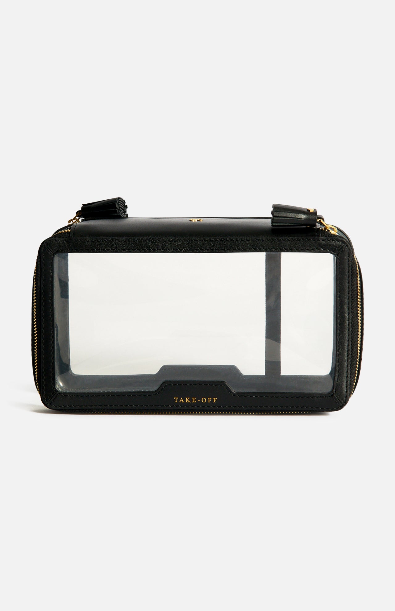 Anya Hindmarch Logo In-Flight Case in black rectangular nylon with a clear front panel, gold zip closure, and TAKE-OFF embossed in gold near the bottom.