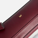 Burgundy Logo In-Flight Case featuring a small gold bow emblem.