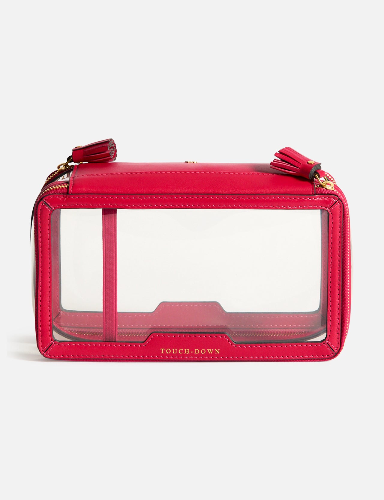 Anya Hindmarch Logo In-Flight Case, a rectangular red bag with clear side panels, two zipper pulls with tassels, and TOUCH-DOWN printed in gold lettering on the front.