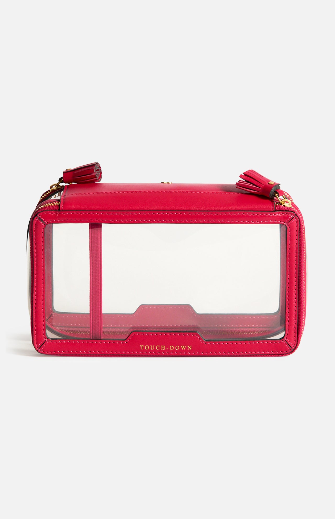 Anya Hindmarch Logo In-Flight Case, a rectangular red bag with clear side panels, two zipper pulls with tassels, and TOUCH-DOWN printed in gold lettering on the front.