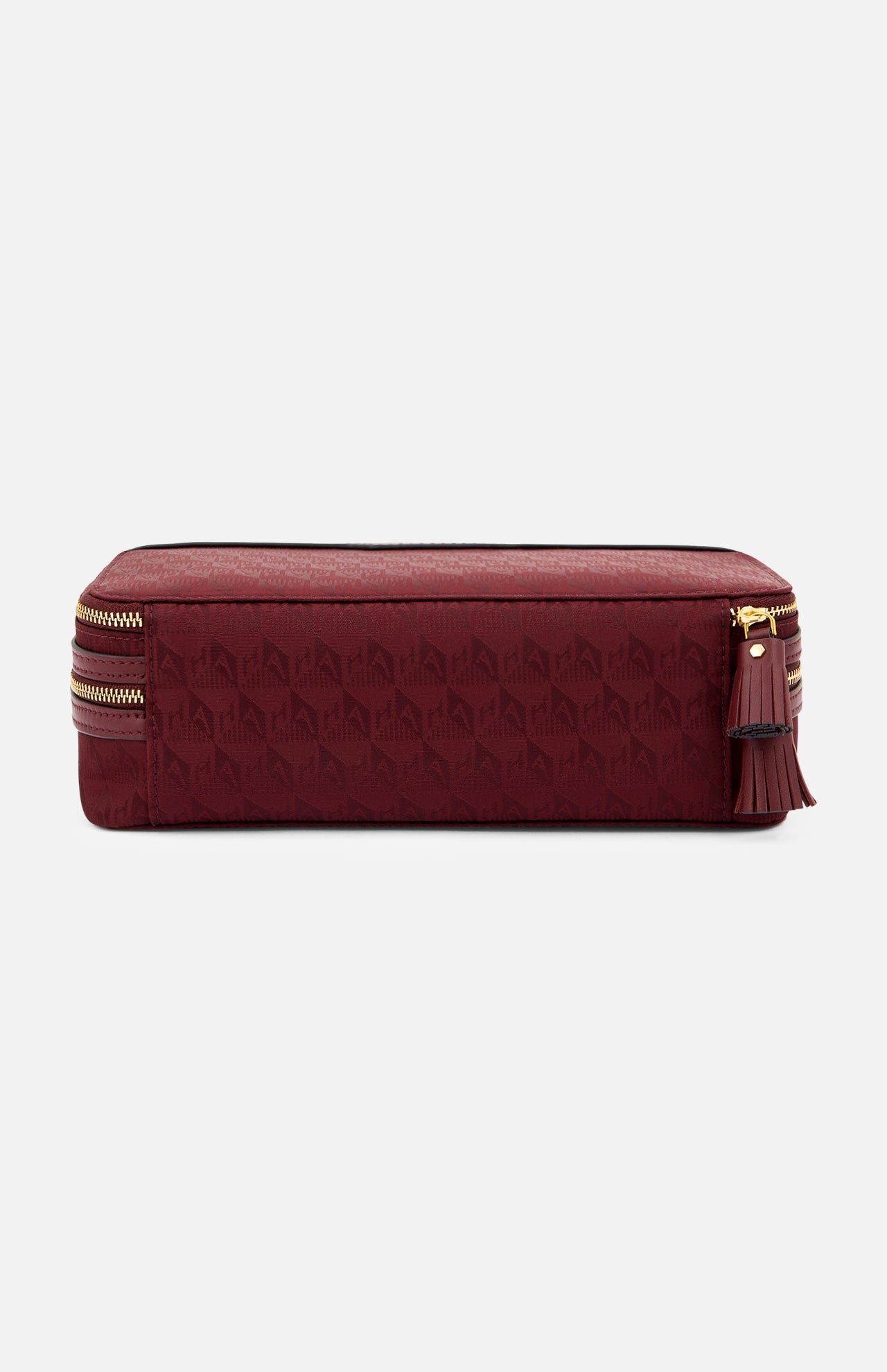 Anya Hindmarch Logo Make-Up Pouch in burgundy with a repeating geometric pattern, gold zipper, and leather tassel pull.