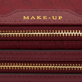 Close-up of a deep red, Italian-made Anya Hindmarch Logo Make-Up Pouch with gold zippers and the word MAKE-UP embossed on a leather tab.