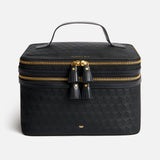 Black Anya Hindmarch Logo Vanity Kit with a top handle, a double-zippered closure with two leather tassels, and a gold-tone bow emblem on the front.