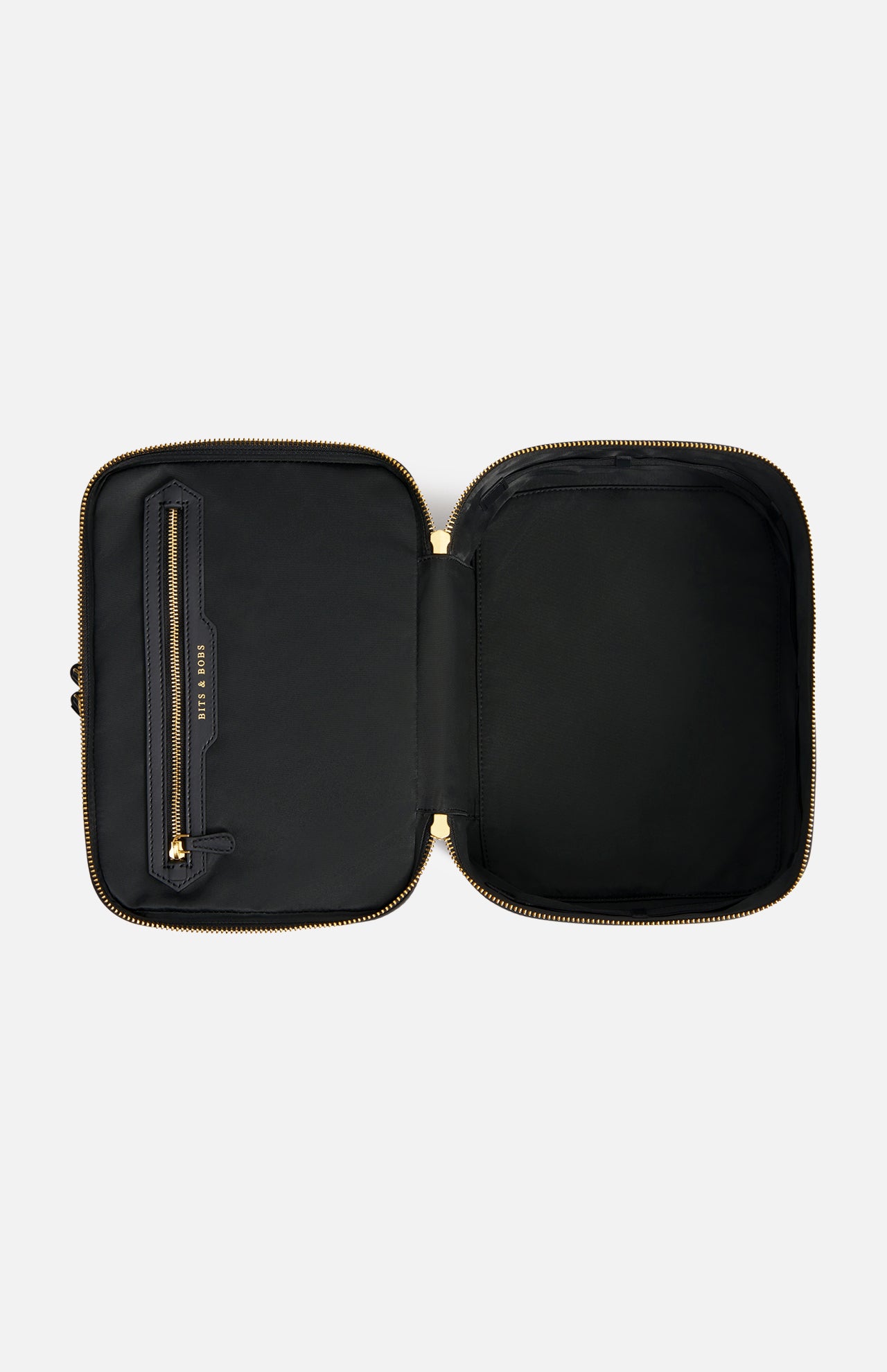 Open black Anya Hindmarch Logo Vanity Kit with a gold zipper and a pocket labeled BITS & BOBS.