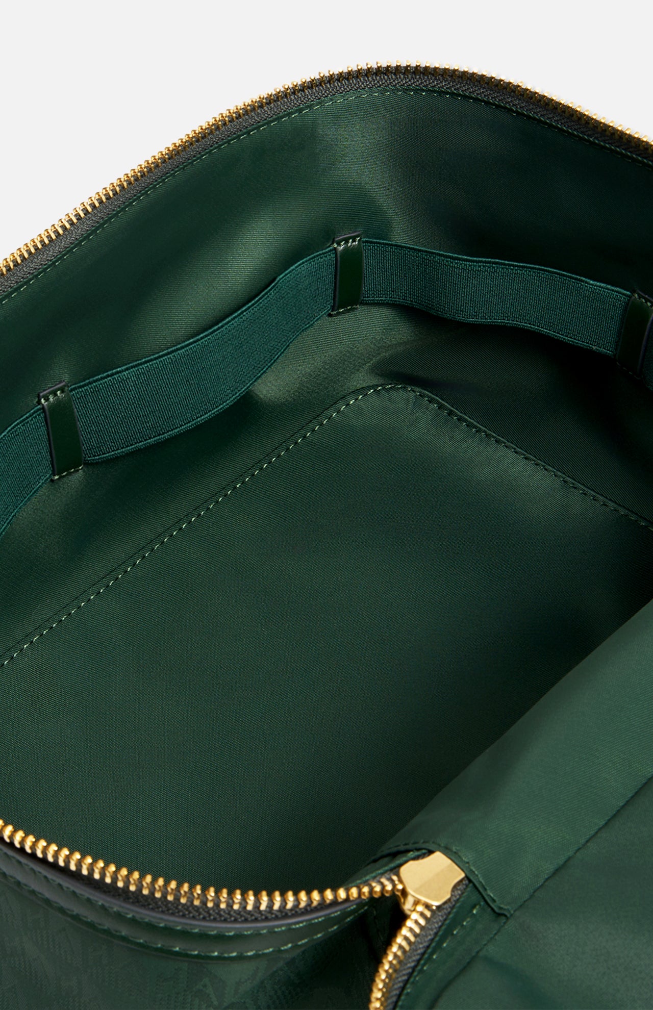 The interior of a dark green Anya Hindmarch Logo Vanity Kit, featuring a zippered pouch with an elastic loop strap along the back wall.