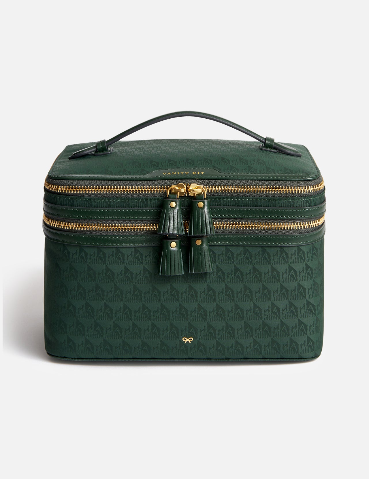 Anya Hindmarch Logo Vanity Kit: a dark green rectangular makeup brush organizer with a top handle, two-way zipper closures featuring tassel pulls, and an all-over repeating geometric pattern.